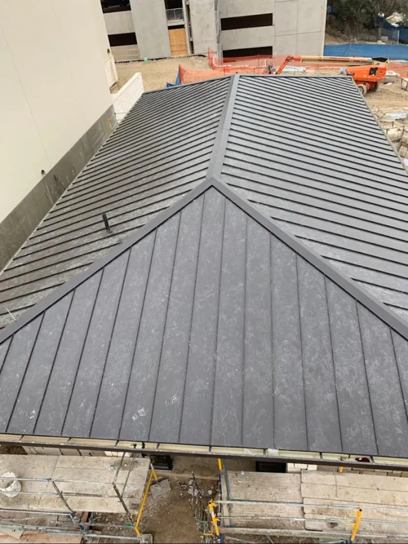 Commercial metal roof construction with crane equipment in Perry Heights