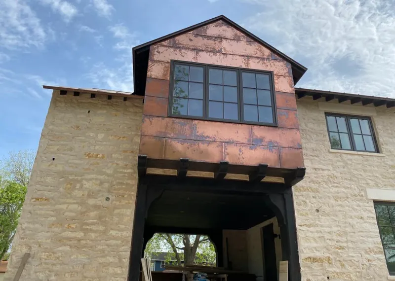 Copper metal panel facade on a stone building for Roof Repair in Perry Heights